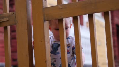 niño pequeño en la puerta de la cerca del jardín, concepto de resolución de problemas infantiles