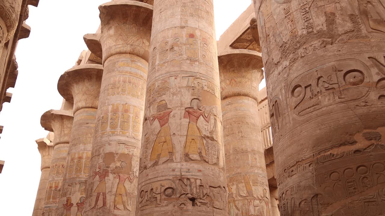 foto panorámica de altas columnas llenas de jeroglíficos en la sala hipóstila del templo de karnak en luxor, egipto