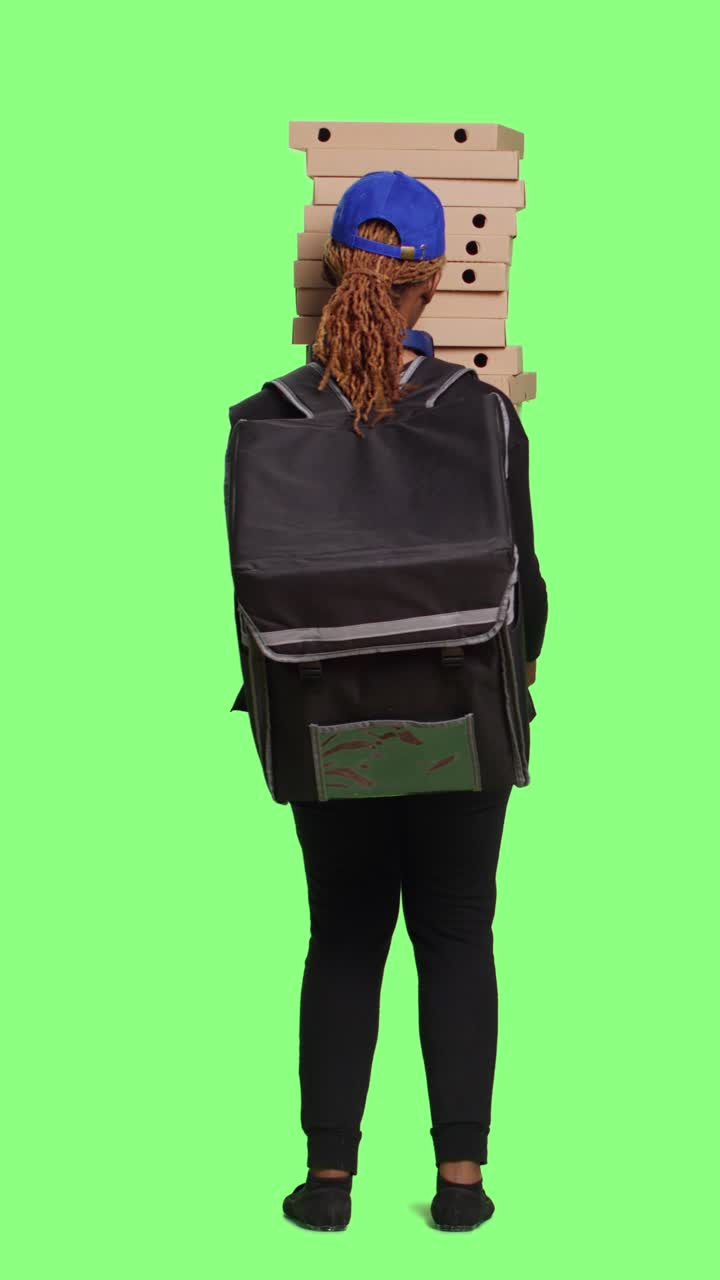 Female model carrying huge pile of pizza boxes to deliver meal