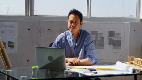 front view of asian male architect using laptop on desk in a modern office 4k