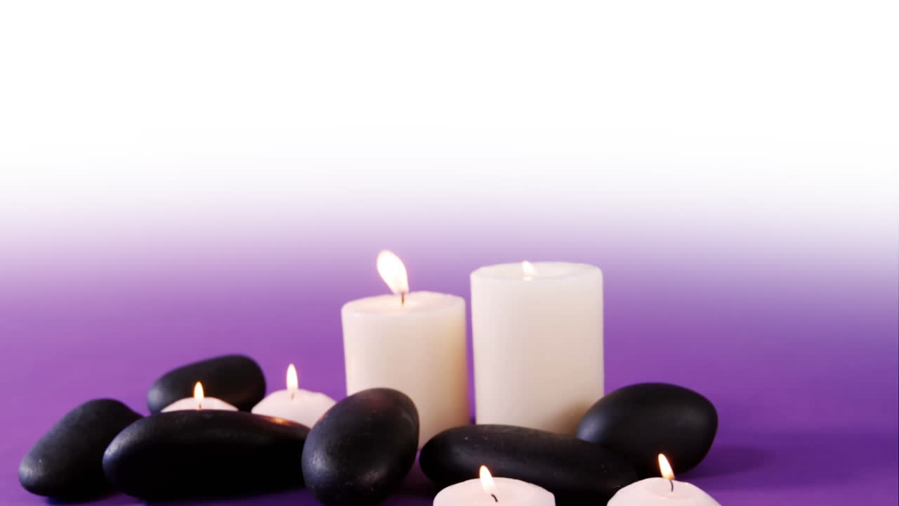 animación de rocas negras y velas blancas sobre un fondo blanco y púrpura