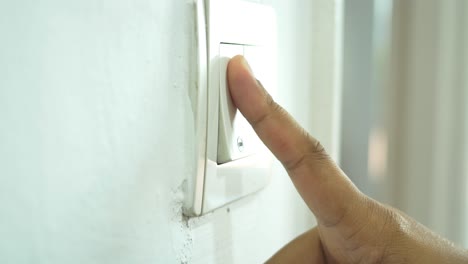 mano encendiendo un interruptor de luz