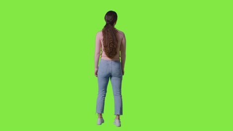 full length rear view studio shot of woman looking all around frame against green screen in vr environment 2