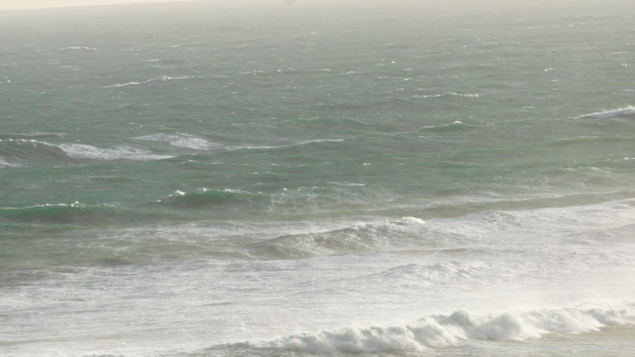 역동적인 파도가 오스트레일리아의 위대한 바다 도로를 따라 해안에 부히고, 부드러운 자연 조명과 조용한 분위기로 포착되었습니다.