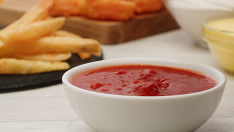 sumergiendo las papas fritas a mano en ketchup
