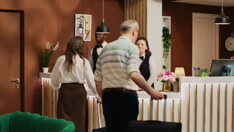 retired couple arrive at hotel reception