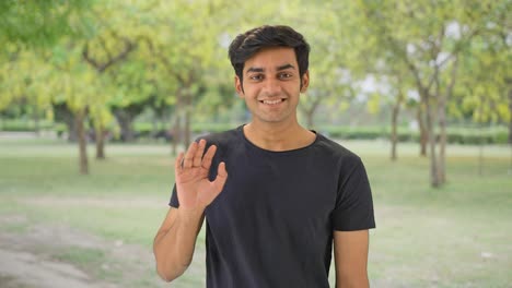 happy young indian boy saying hello