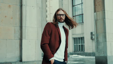 atractivo hombre hipster barbudo en abrigo de moda rojo