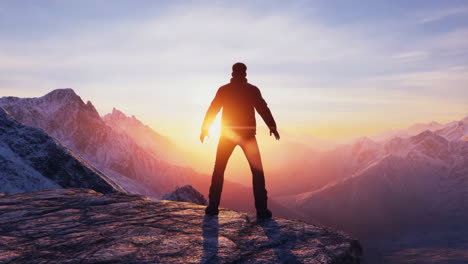 man standing on a mountain at sunset