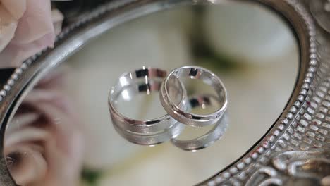 two beautiful precious rings are lying on a mirrored tray. close-up shooting