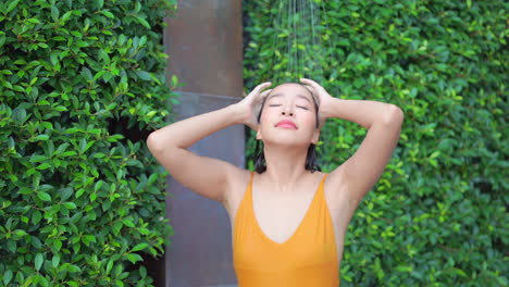 An-attractive-woman-in-a-bathing-suit-showers-poolside-to-wash-the-coloring-from-the-pool-away