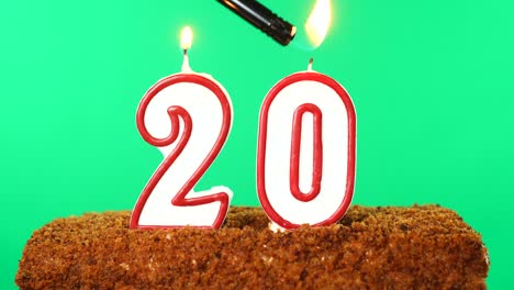 cake with the number 20 lighted candle. chroma key. green screen. isolated