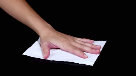 a hand cleans a surface using a cloth