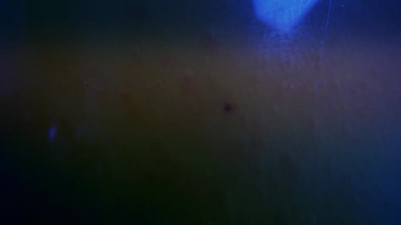 실험실의 탱크 안에 있는 파란색, 녹색, 노란색의 거품이 이는 액체