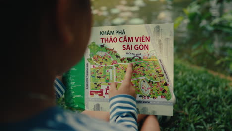 child looking at a map of the ho chi minh zoo