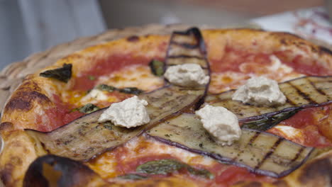 chef puts humus topping onto freshly baked neapolitan pizza