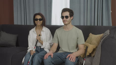 Camera-zoom-out-on-blind-friends-sitting-on-a-sofa-in-a-flat