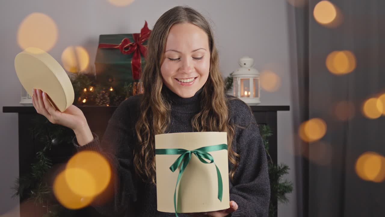 mujer abriendo regalo en la víspera de navidad