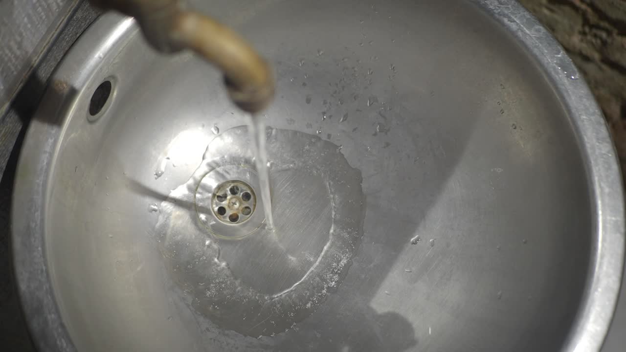 밖의 금속 싱크와 흐르는 물