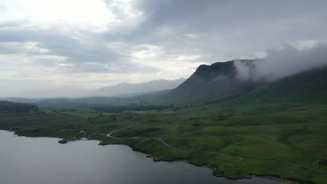 Aerial-landscape-shot-of-a-lake-surrounded-by-mountains,-in-the-English-Lake-District,-sunset