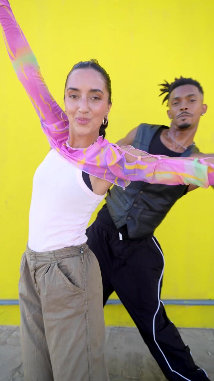 Young Couple Dancing Together Against a Bright Yellow Wall