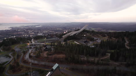 flying over midtstubakken and holmenkollbakken at holmenkollen national arena in oslo, norway. aerial wide