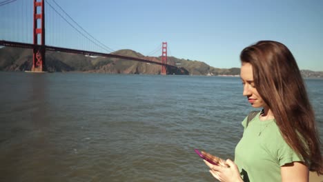 mujer fotografiando el puente golden gate, san francisco