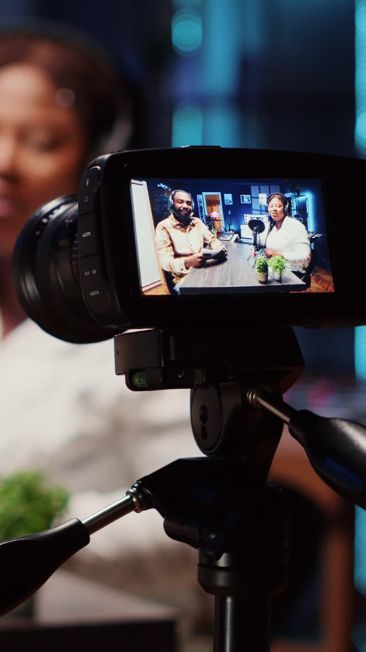 Vertical video Professional camera recording man in blurry background interviewing guest