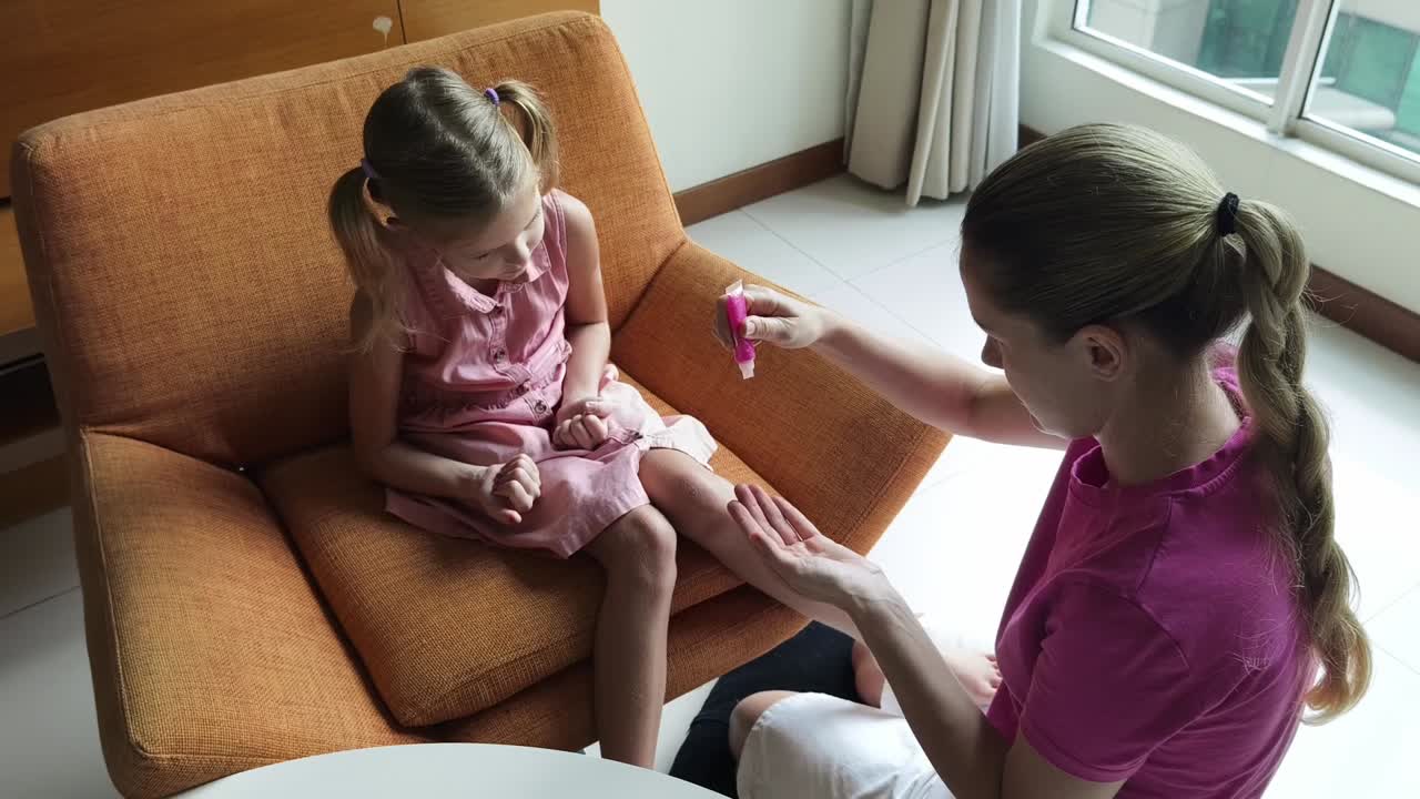 어머니 가 딸 의 무 에 크림 을 붙이고 있다