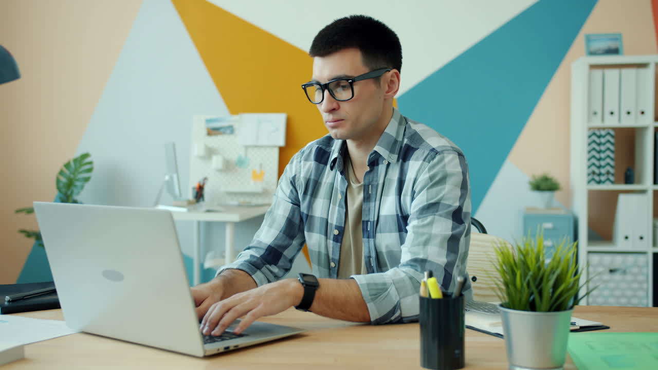 Hombre que trabaja en la computadora portátil en la oficina