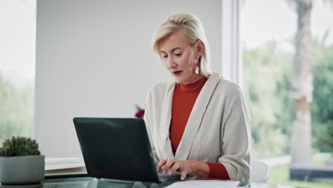 una mujer mayor sonriente trabajando en una computadora portátil