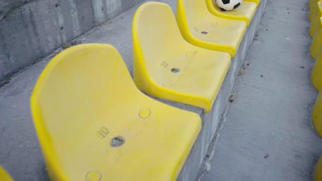bola de fútbol en el podio del estadio. sillas amarillas vacías