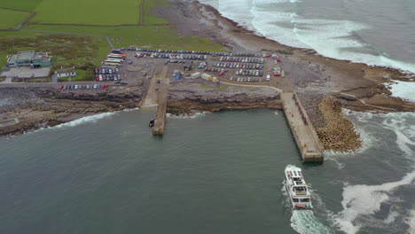 static bird’s-eye aerial captures the aran islands ferry arriving at doolin pier. county clare, ireland