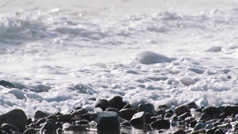 60fps:-Las-Olas-Rompen-En-Una-Playa-De-Piedra-En-Barcelona-Creando-Hermosos-Reflejos---Toma-Ampliada