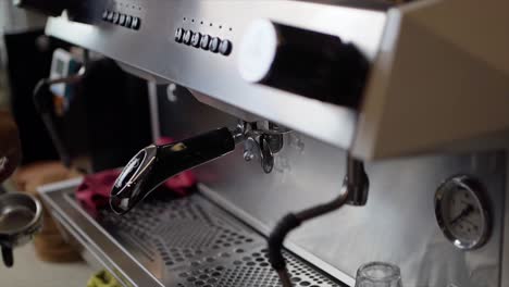 barista male hands holding portafilter and making fresh aromatic coffee at cafe using a modern coffee maker in coffee shop