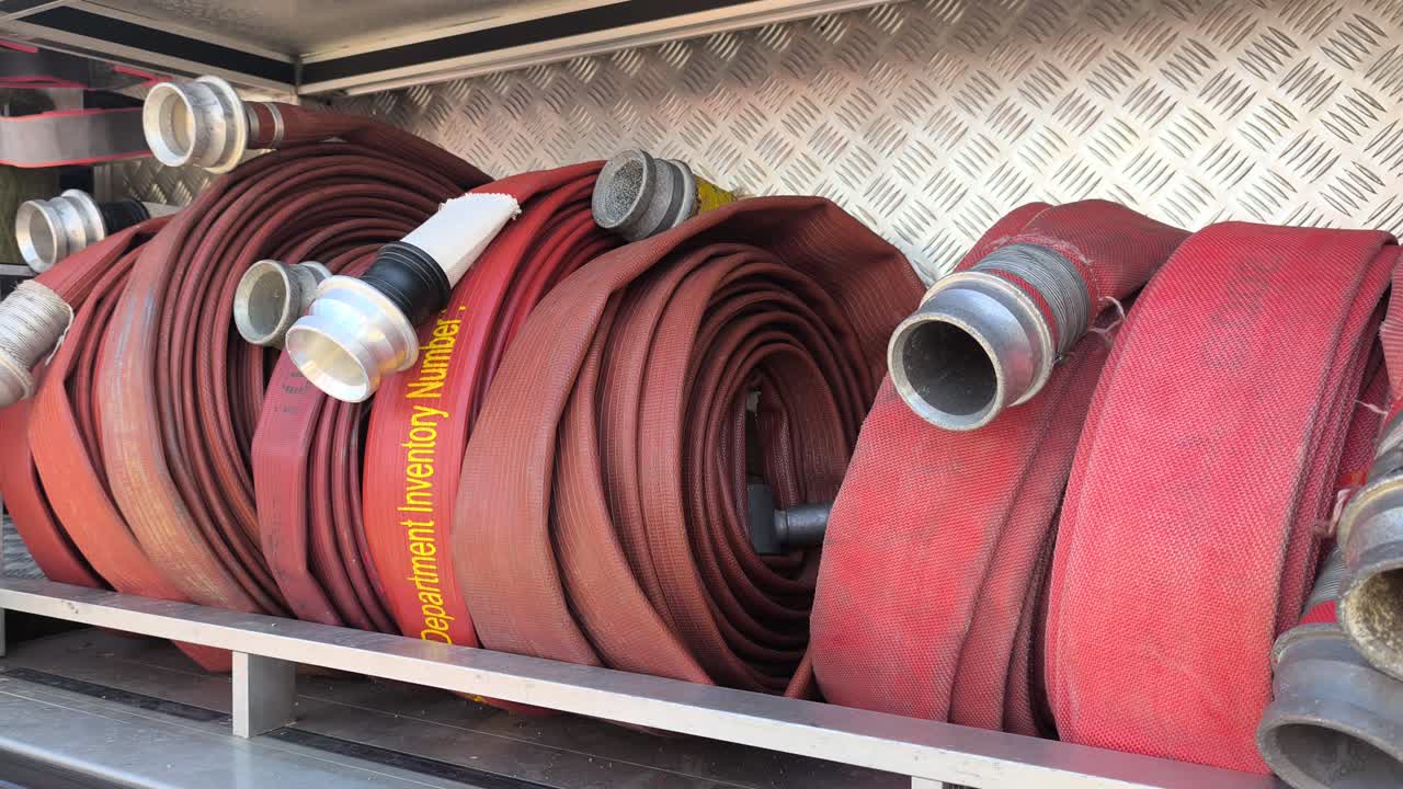 Rolled fire hoses stored inside a fire truck. These tools are ready for emergency response. They are designed to withstand and deliver high-pressure water flow