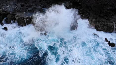 oleaje estacionario de olas que se estrellan contra acantilados volcánicos de roca negra