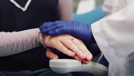 dentist comforting patient with hand