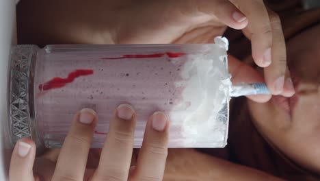 woman drinking a strawberry smoothie