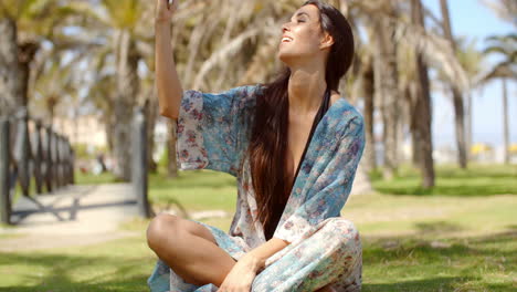 pretty girl resting on ground talking selfie