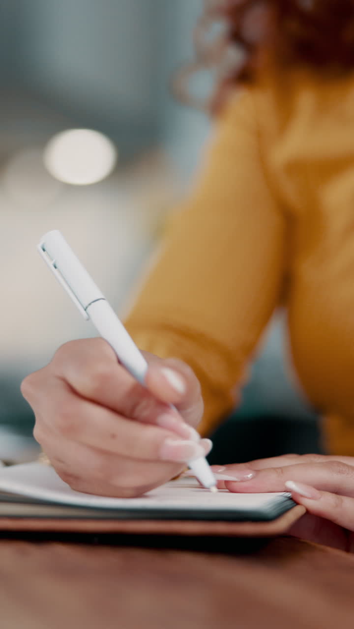 Woman writing in a notebook with a pen