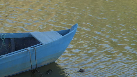 imagen de una parte de un barco artesanal azul, embarcado en el río