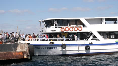 ferry boat docked at a pier with people boarding