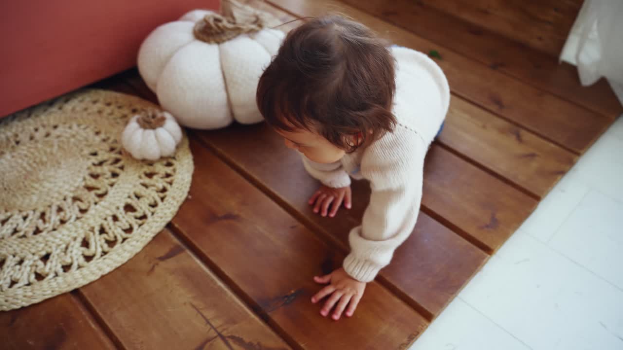 Bambino carino che gattona ed esplora su un pavimento di legno