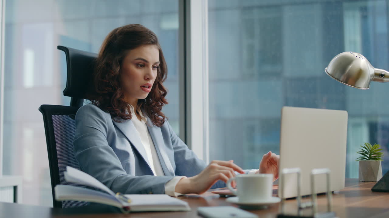 donna d'affari scioccata dal fallimento che legge cattive notizie all'ufficio del portatile da vicino.