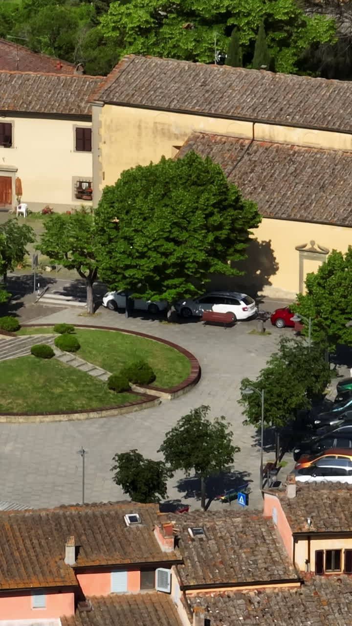 Ripresa aerea verticale con drone delle strade di un'idilliaca cittadina, giornata di sole in Toscana, Italia