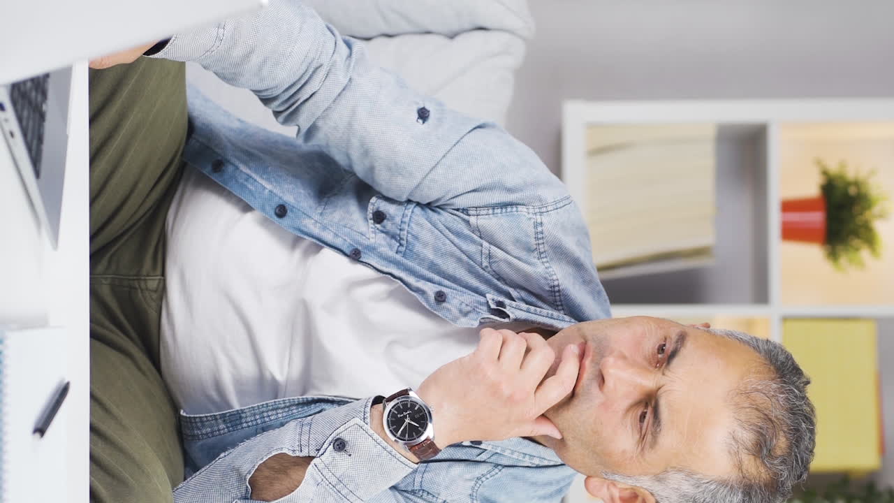 vídeo vertical de satisfecho con lo que ve en la computadora portátil, el hombre asiente.