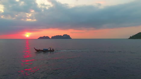 Una-Vista-Aérea-Baja-Del-Barco-Tailandés-De-Cola-Larga-Al-Atardecer