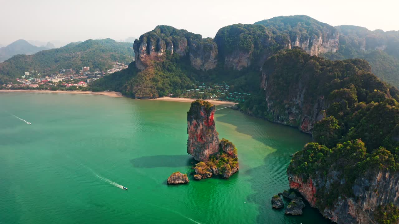 Bright midday shot of Railay Beach, Krabi. Aerial drone view of vibrant turquoise waters and limestone cliffs. Perfect for vacation ads, tropical promotions, and scenic b-roll.