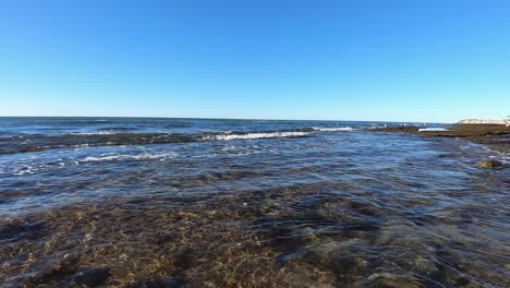 Die-Kamera-Am-Wasserspiegel-Fängt-Einen-Einsamen-Seevogel-Ein,-Der-Den-Horizont-überquert,-Puerto-Peñasco,-Golf-Von-Kalifornien,-Mexiko